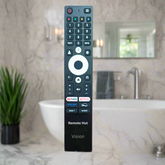 Black remote control with multiple buttons on a red surface